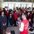 A man in a red and white jacket speaks a crowd in Blackwell Hall